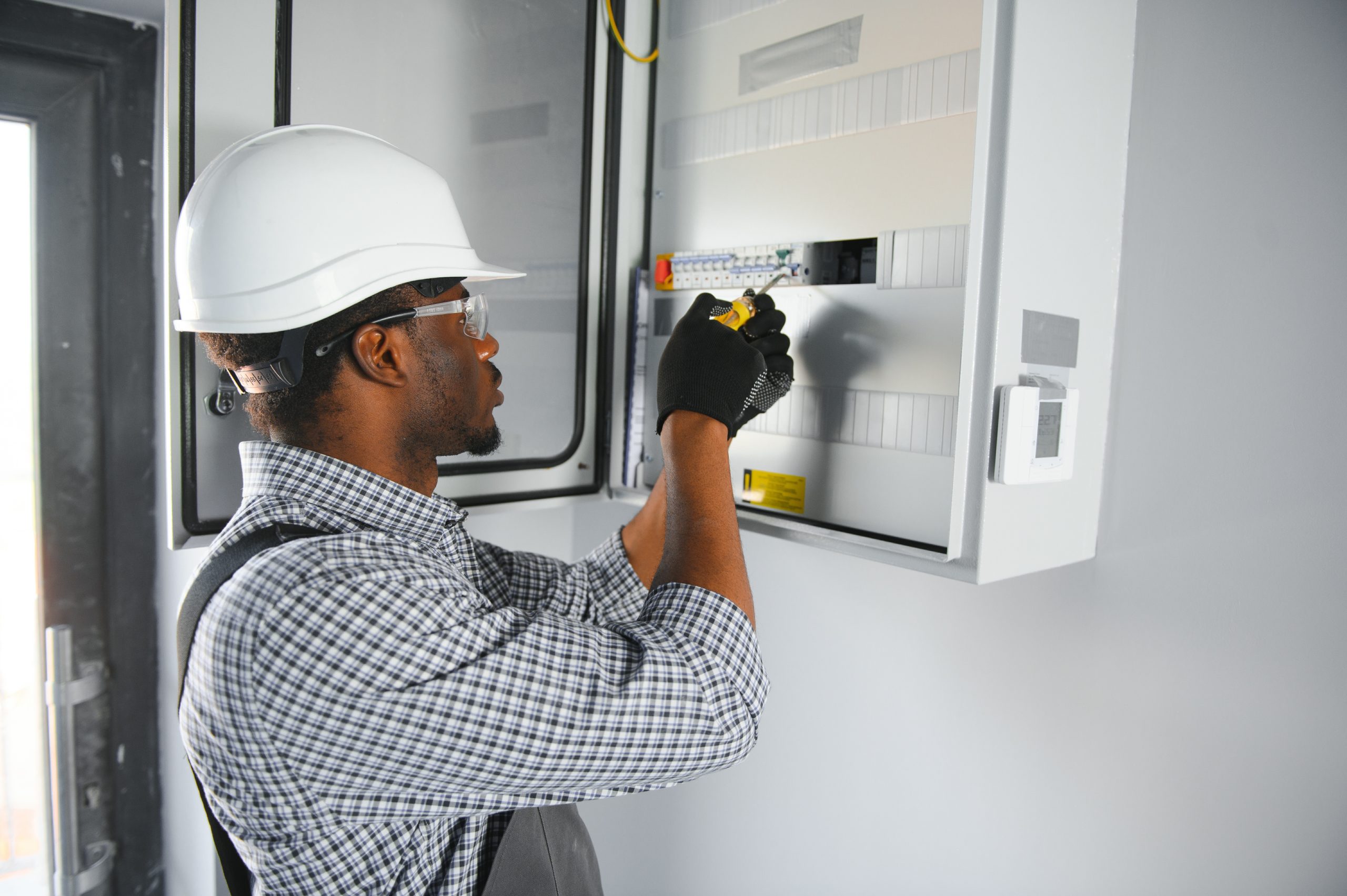 African american electrician Repairing electricity switchboard