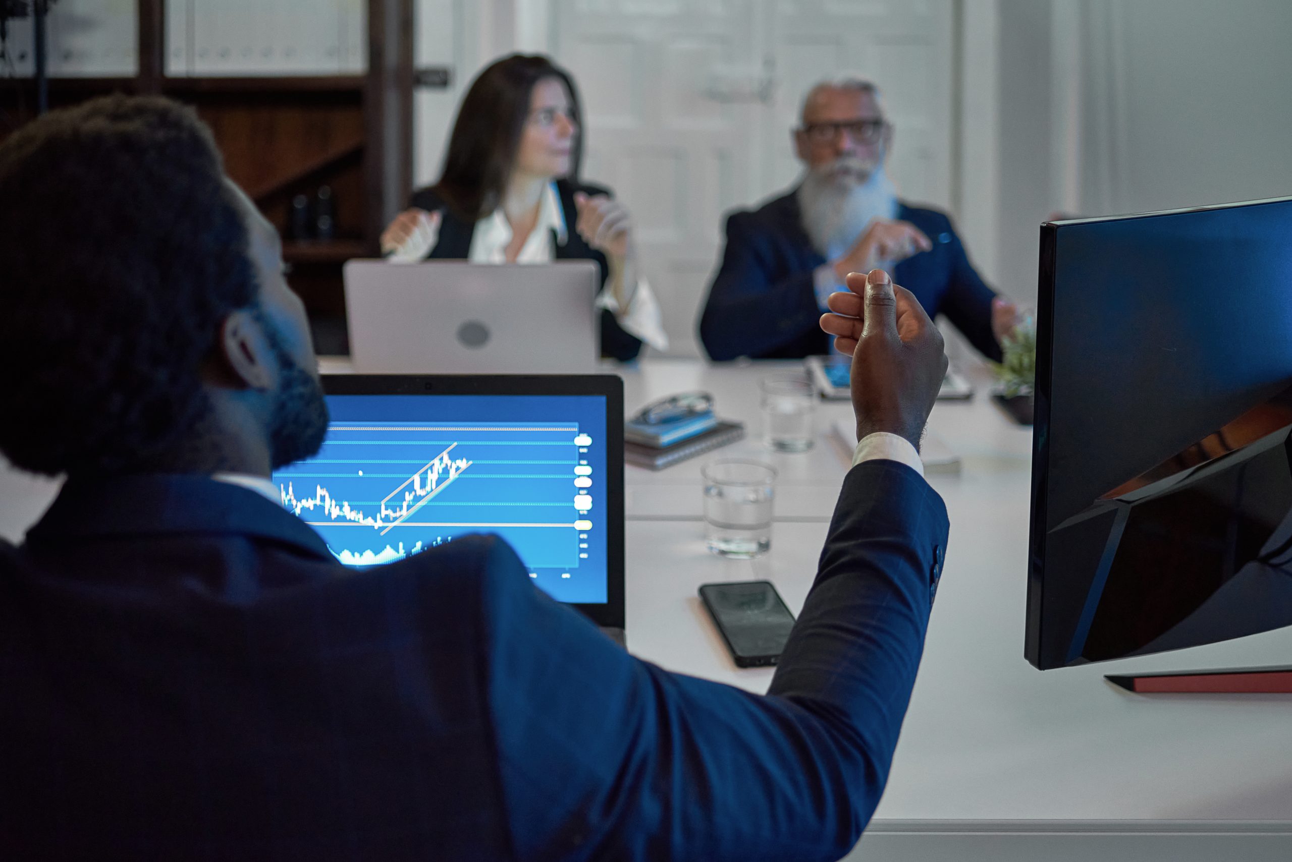 Anonymous black worker interacting with partners during meeting in office